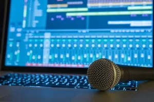 Microphone closeup with mixing board - blue monitor